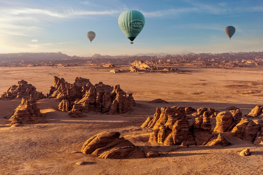 Hot air balloon AlUla flight drifting over the sandstone desert at sunrise