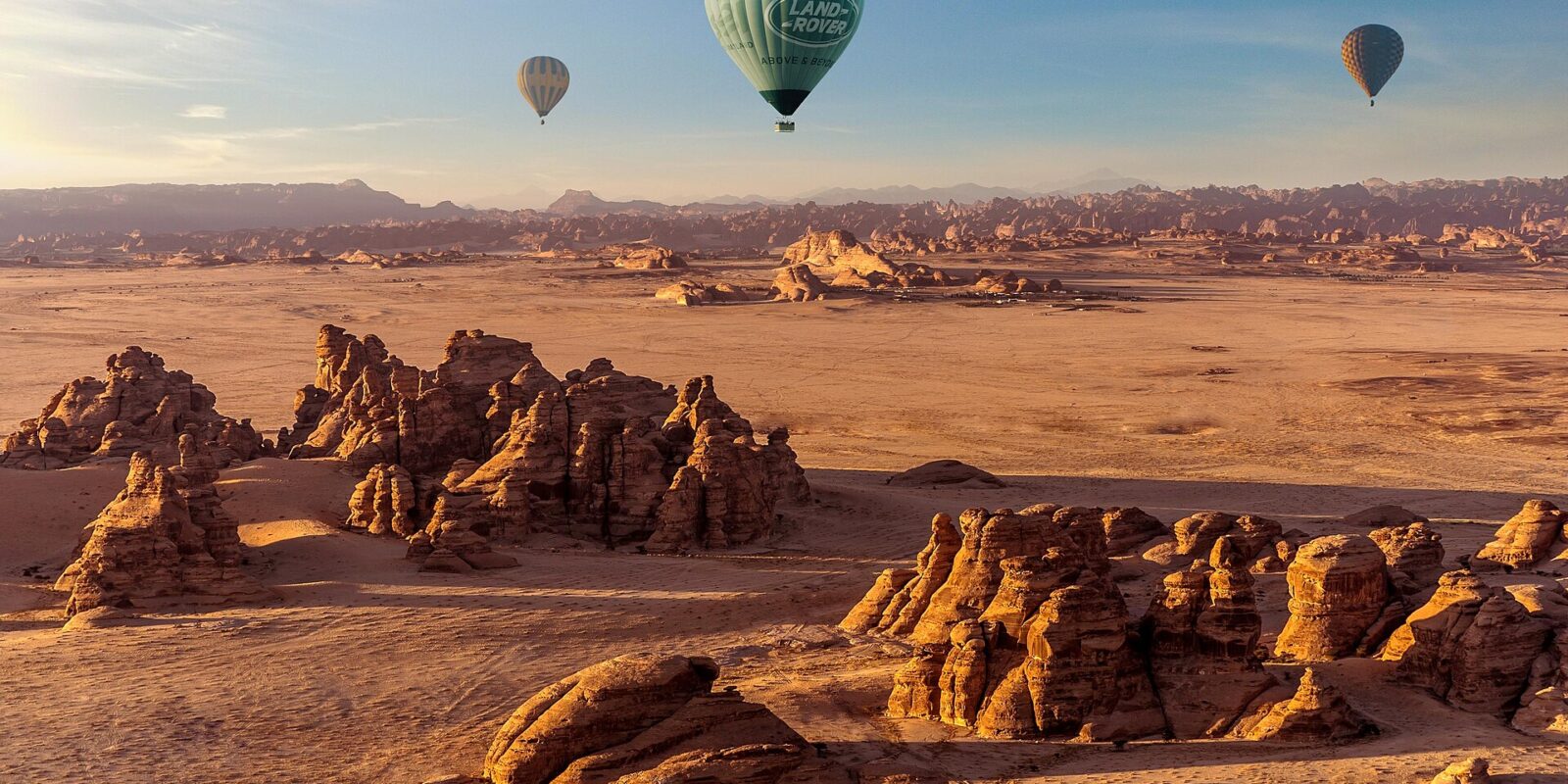 Hot air balloon AlUla flight drifting over the sandstone desert at sunrise