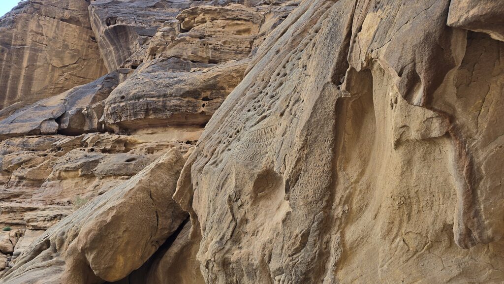 The narrow desert canyon of Jabal Ikmah with carved rock-art panels near AlUla
